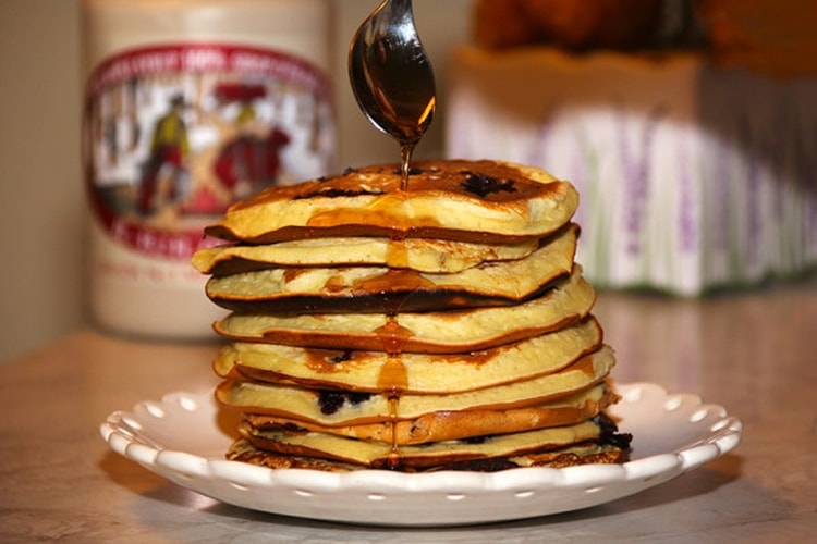 Des pancakes avec une montagne de sirop d'érable 