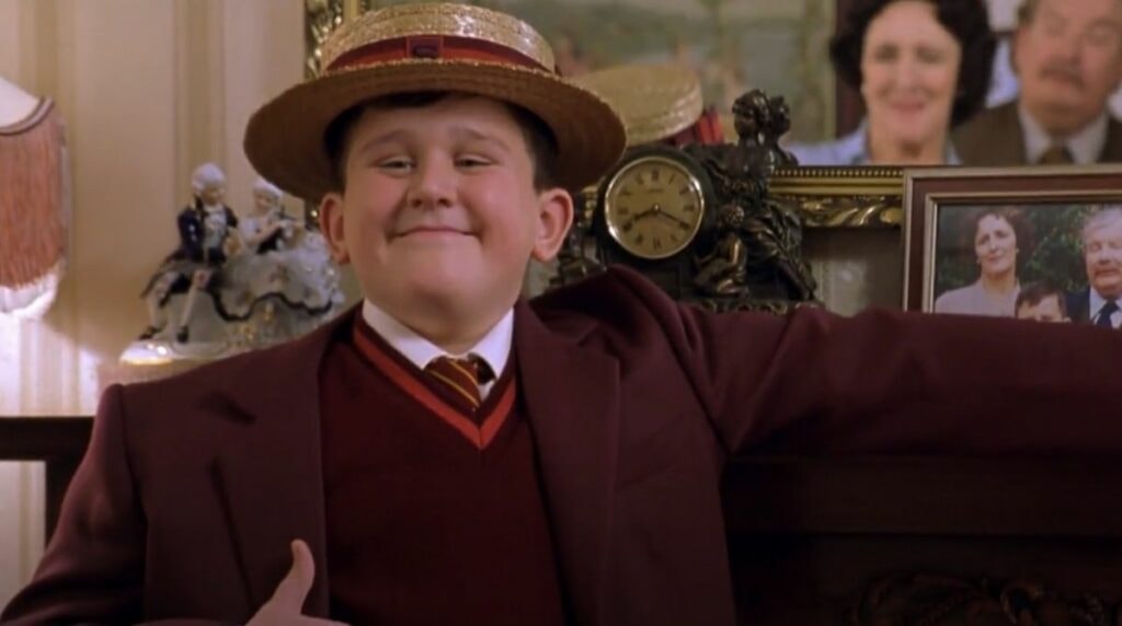 harry melling dans le rôle de dudley dursley dans harry potter à l'école des sorciers portant son uniforme de smelting