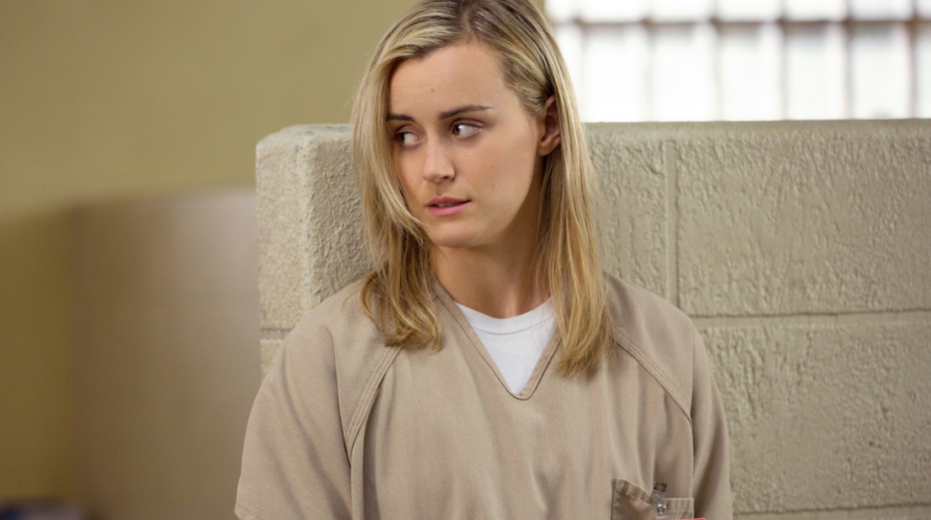 Piper vêtue de son uniforme de prisonnière dans la série Orange is the new Black, interprétée par Taylor Schilling