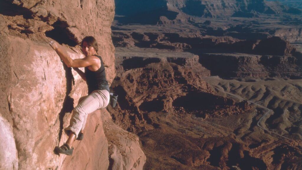 Ethan Hunt escalade une falaise à mains nus dans Mission Impossible 2