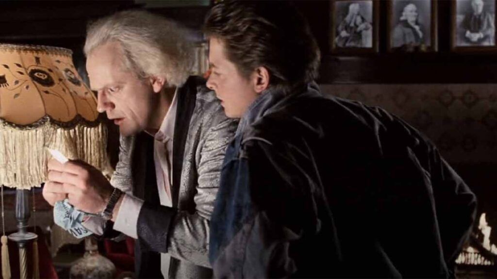 Doc Brown et Marty McFly regardent une photo dans Retour vers le Futur