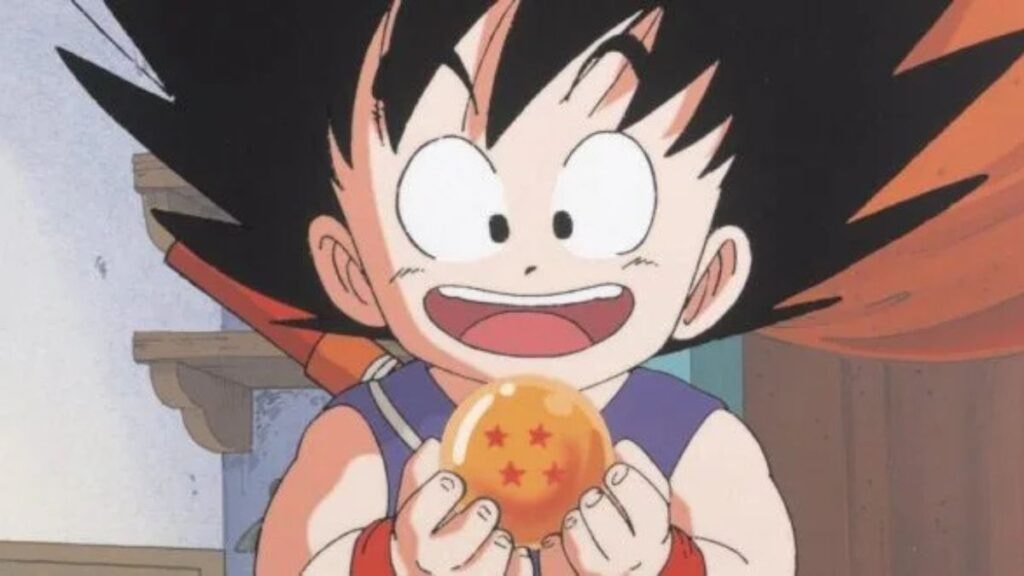 Goku enfant, tenant en souriant la boule de cristal de son grand-père dans l'anime Dragon Ball