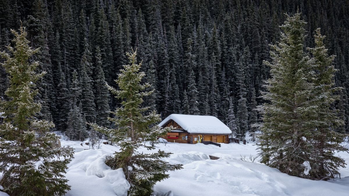 Un chalet perdu au milieu des montagnes enneigées