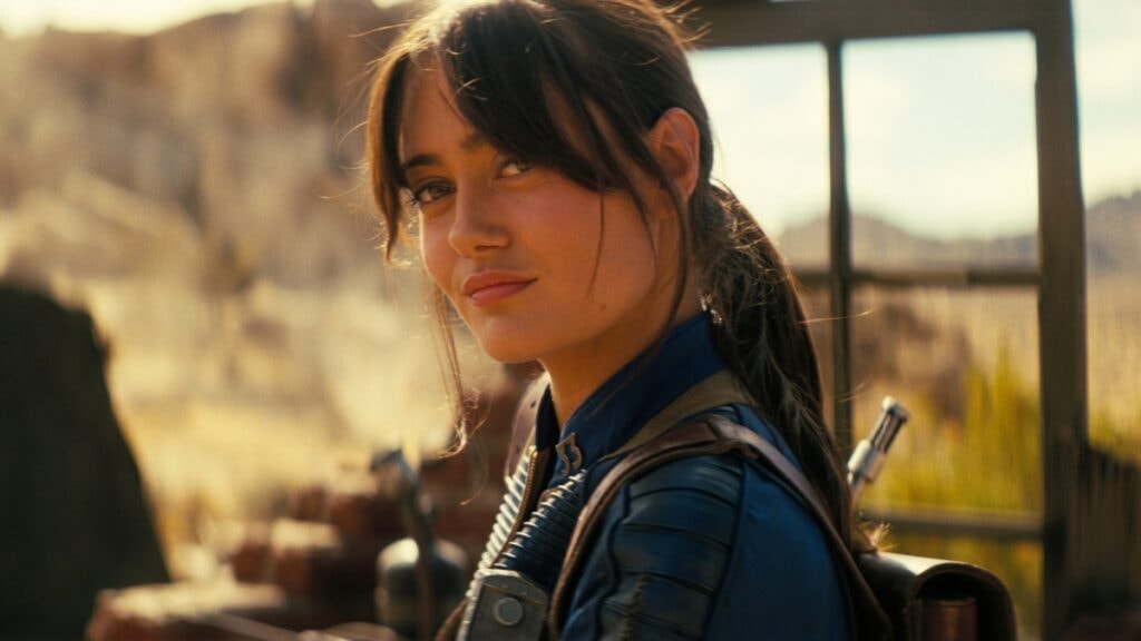 Lucy souriant dans le désert de la saison 2 de Fallout