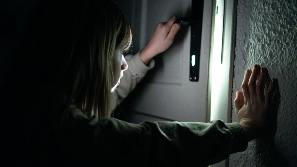 Image d'une femme qui regarde par la porte / un secret